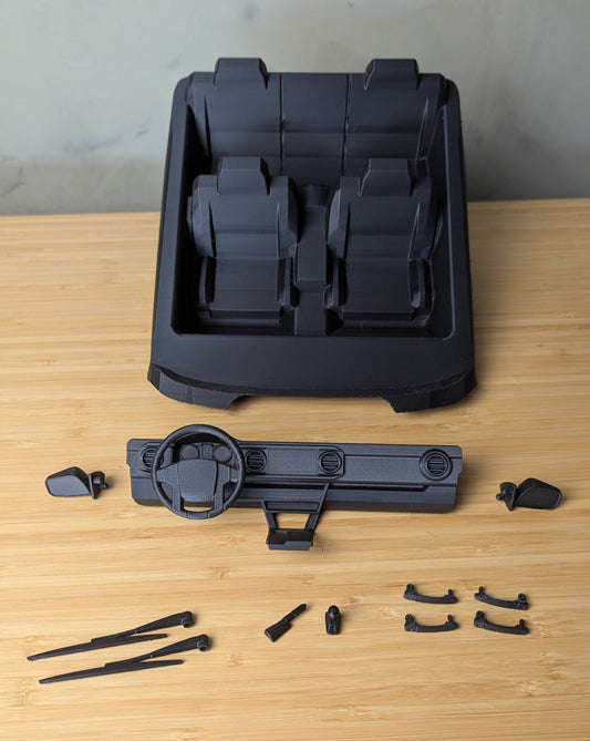 3d printed Knightrunner scale interior components on a wooden surface with a gray background